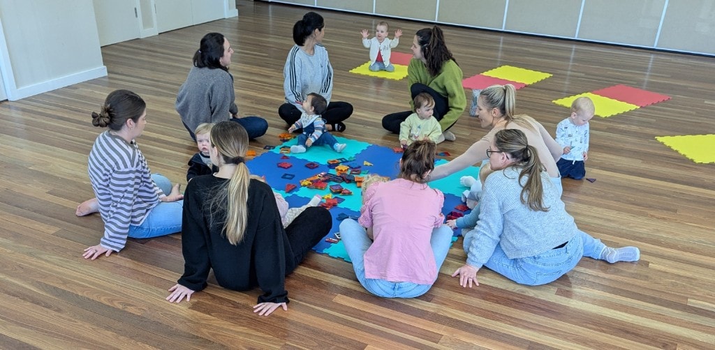 Wide view of a Tiny Moves class in a spacious, light-filled community hall